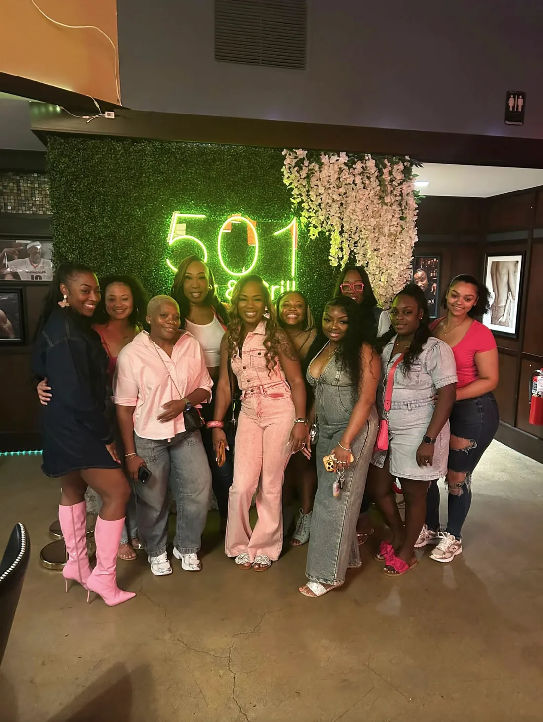 Guests gathered in front of the neon 501 sign at 501 Bar and Grill