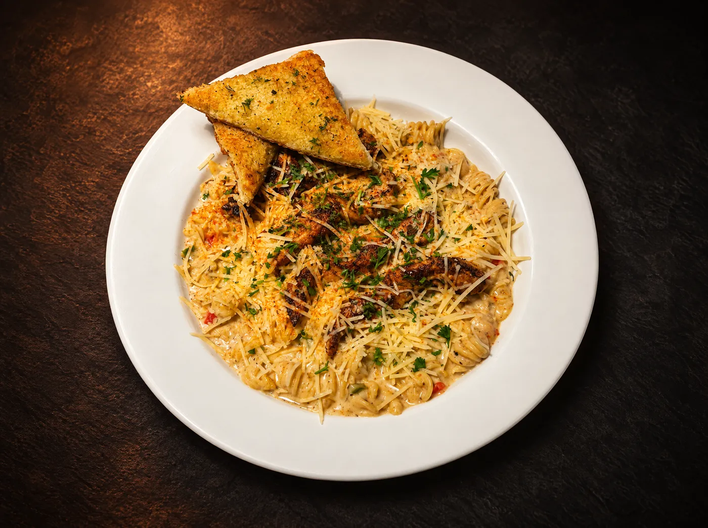 Creamy Cajun pasta with blackened chicken, parmesan and garlic toast