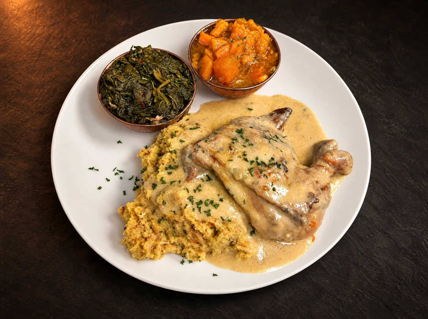 Sunday baked chicken over cornbread dressing with greens and candied yams